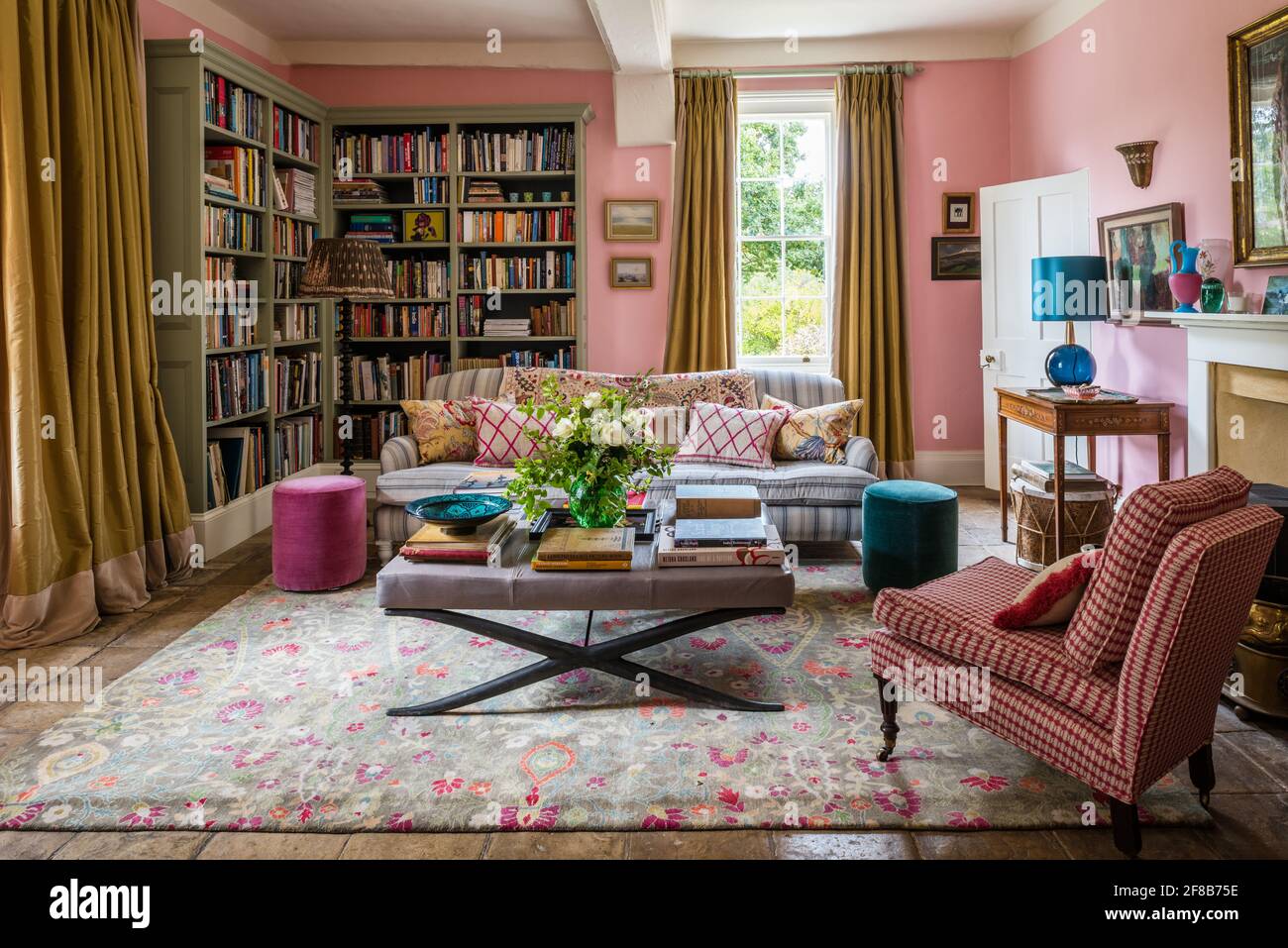 George Smith divano e tende d'oro con sedia imbottita in tessuto di Allegra Hicks in soggiorno della casa colonica Suffolk, pareti in Squid Ink da Pain Foto Stock