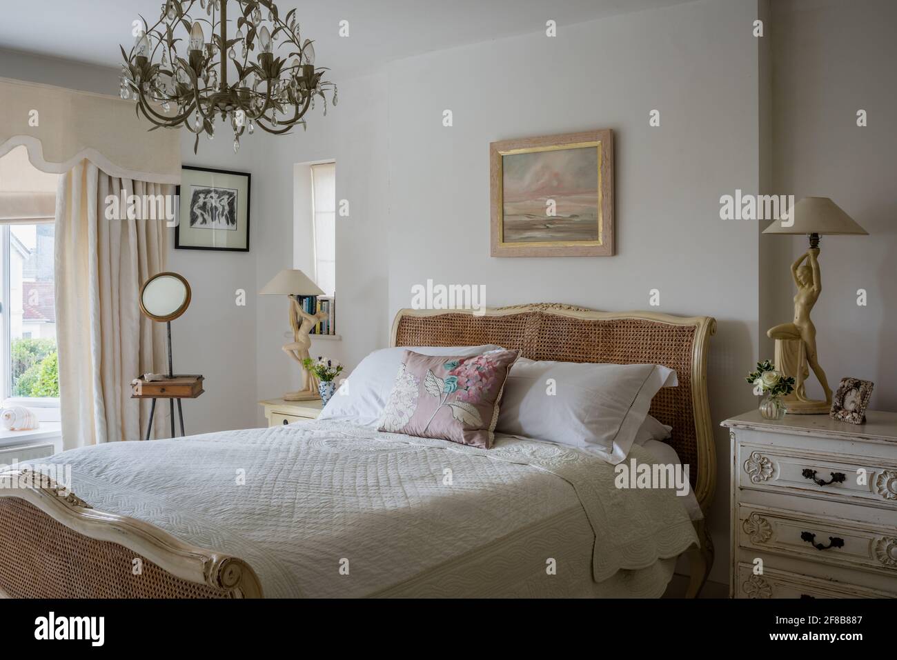 Lampade art deco e specchio da barba edoardiano con antico letto in vimini nel West Sussex ristrutturazione costiera. Foto Stock
