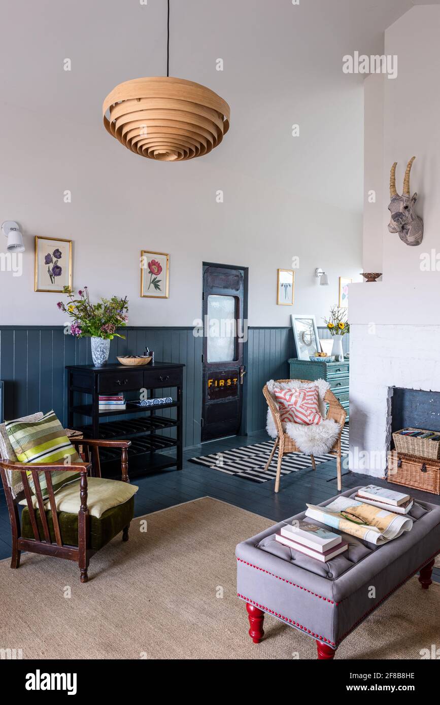 Sedia in vimini con lancio in pelle di pecora e porta originale alla carrozza ferroviaria vittoriana ridisposta in West Sussex casa di vacanza. Foto Stock