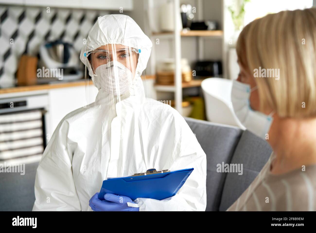 Ritratto di un lavoratore medico in indumenti da lavoro protettivi durante una casa visita Foto Stock