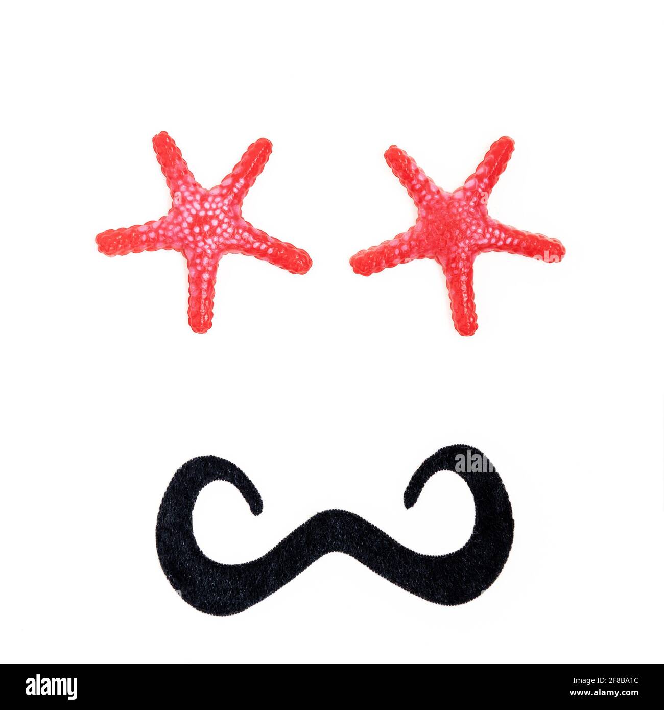 Viso antropomorfo maschile, con occhi di stelle marine e baffi neri Foto Stock