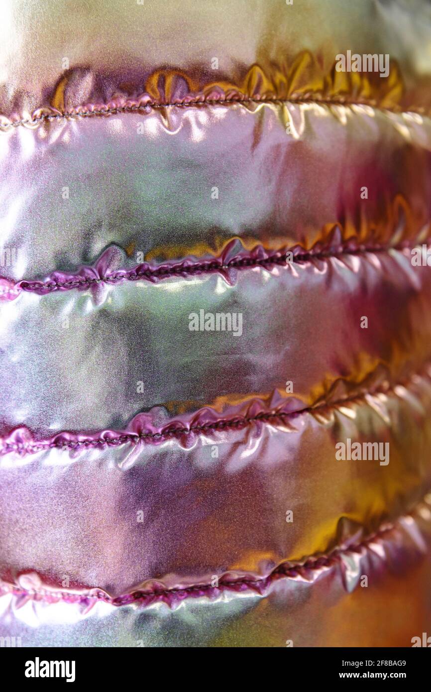 La texture iridescente del tessuto bolognese della giacca giovanile trapuntata. Arcobaleno in stile trendy sfondo. Foto Stock
