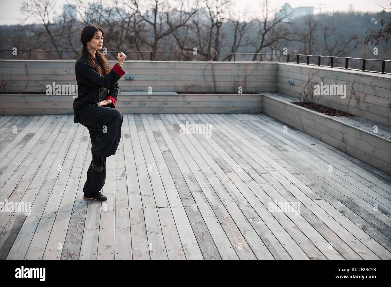 Area esterna vuota con donna in piedi in posizione chi kung Foto Stock