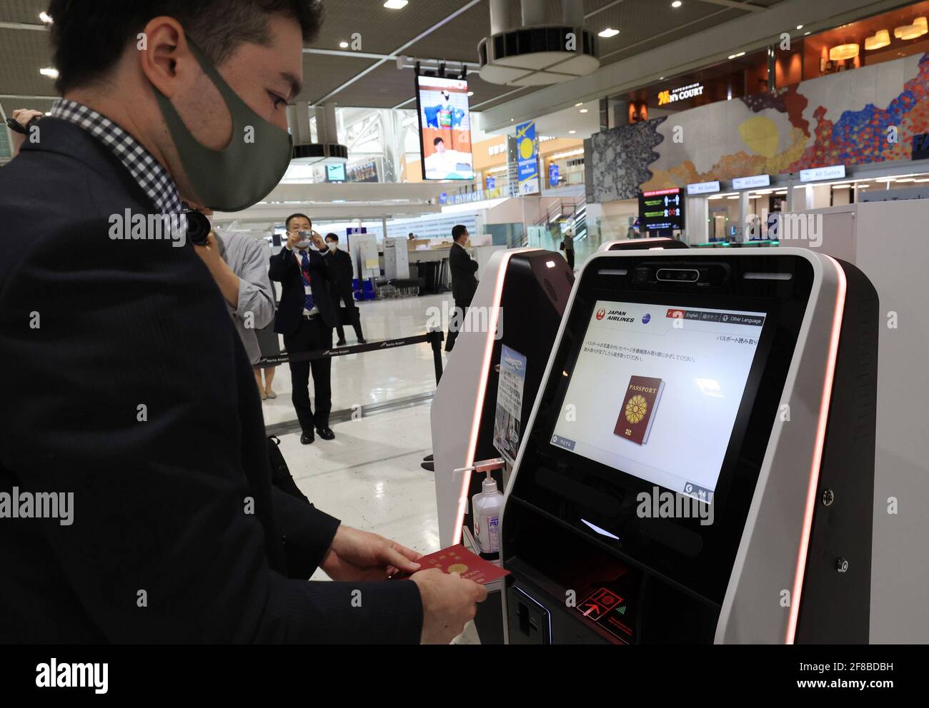 Narita, Giappone. 13 Apr 2021. Un modello dimostra di effettuare il check-in di un chiosco con il passaporto e il riconoscimento facciale presso l'aeroporto internazionale Narita di Narita, nella periferia di Tokyo, lunedì 13 aprile 2021. L'aeroporto internazionale Narita, Japan Airlines (JAL) e All Nippon Airways (ANA) lanciano il nuovo sistema di procedure di partenza all'aeroporto con la tecnologia di riconoscimento facciale "Face Express" di NEC che consente ai passeggeri in partenza di non dover mostrare i propri passaporti e carte d'imbarco al punto di controllo di sicurezza e al gate di imbarco. Credit: Yoshio Tsunoda/AFLO/Alamy Live News Foto Stock