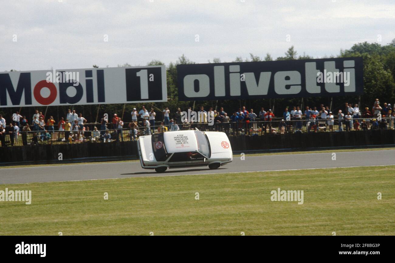 Un pilota stunt in MG Montego si è lambito il circuito di Silverstone su due ruote durante una pausa in qualifica per il Gran Premio del Regno Unito 1987. Foto Stock