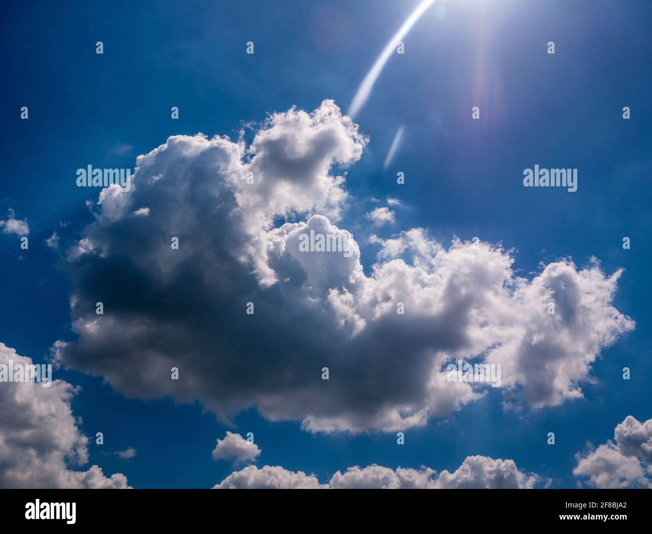 Bella nuvola soffice nel cielo blu, con fascio di sole arrotondato Foto Stock