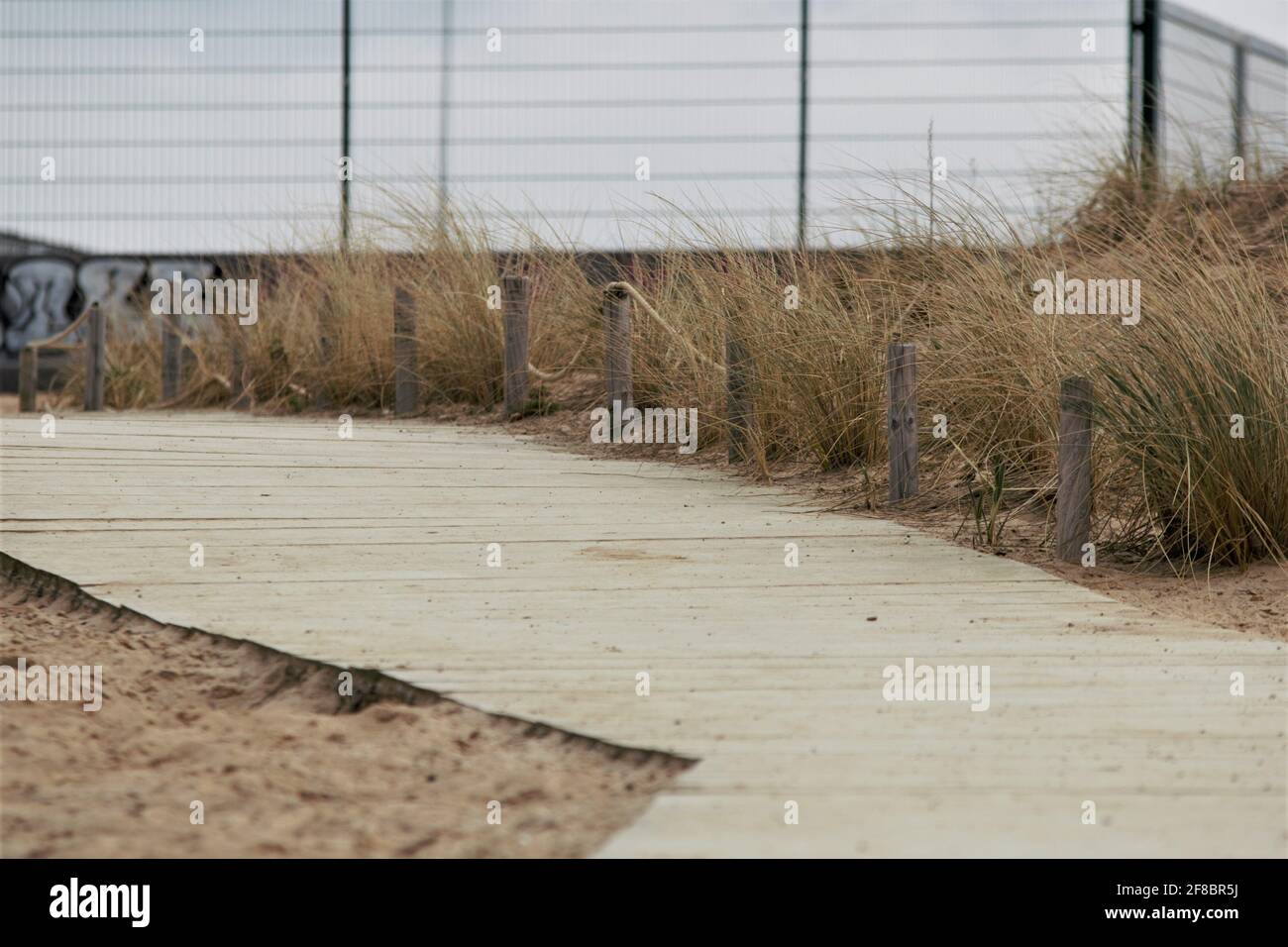 Spiaggia con un percorso in legno come un primo piano su un giornata fredda Foto Stock