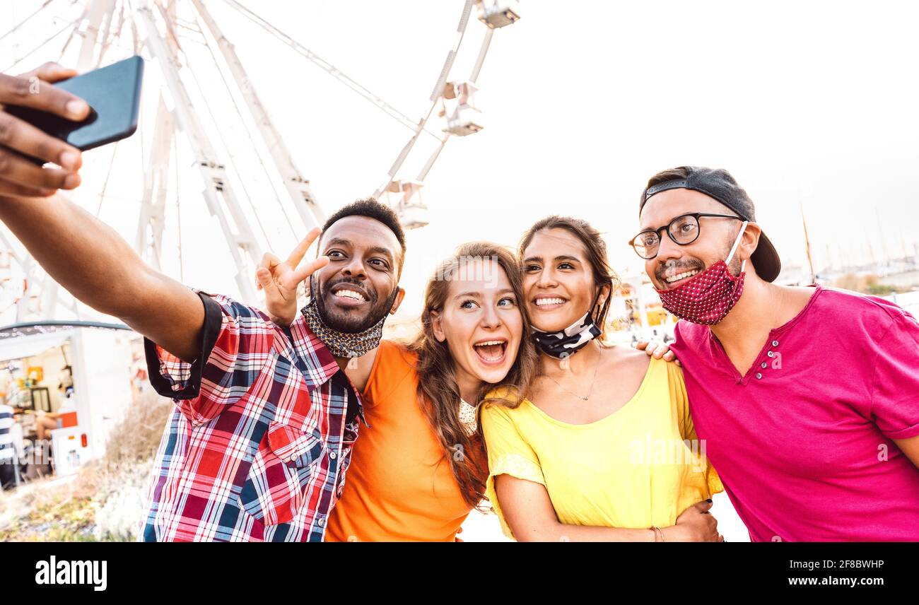 Multiculturale felici viaggiatori che prendono selfie indossando maschere aperte - Nuovo concetto di stile di vita di viaggio normale con i giovani amici che hanno divertimento insieme Foto Stock