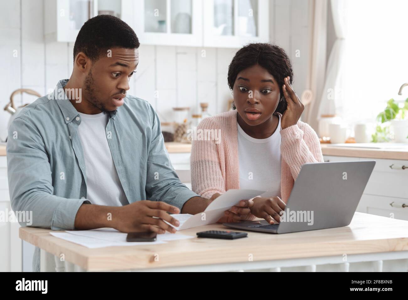 Portraif di scosso sposi neri che verifica documenti finanziari in cucina Foto Stock