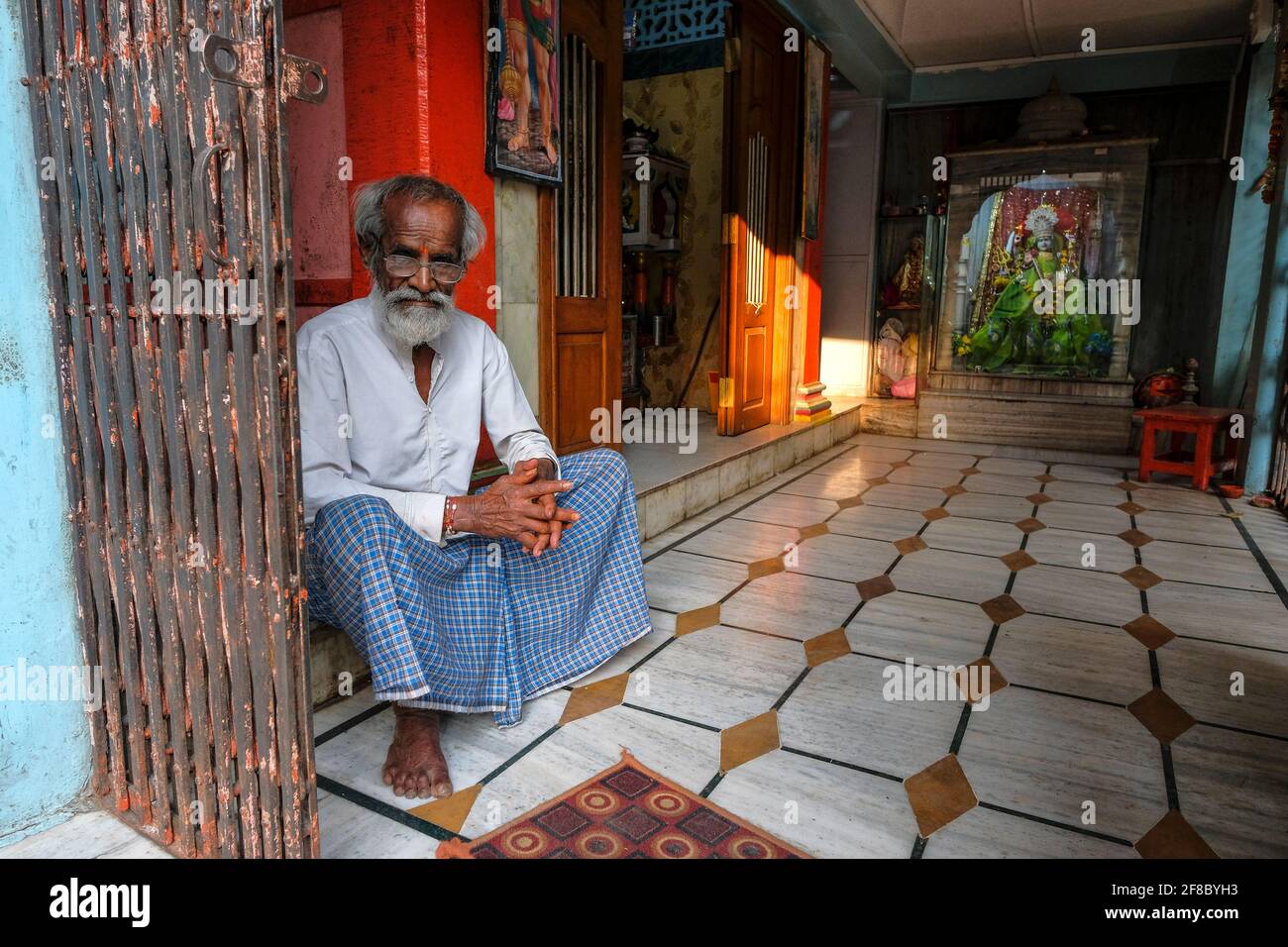 Indore, India - 2021 marzo: Un uomo seduto all'interno di un tempio indù a Sarafa Bazaar il 12 marzo 2021 a Indore, Madhya Pradesh, India. Foto Stock