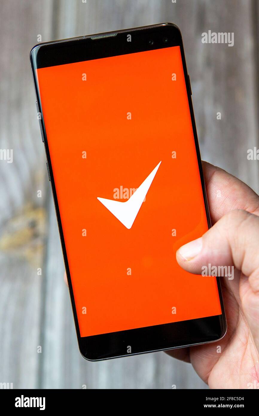 Un telefono cellulare o un telefono cellulare in attesa in un Mano con l'app fattura semplice aperta sullo schermo Foto Stock