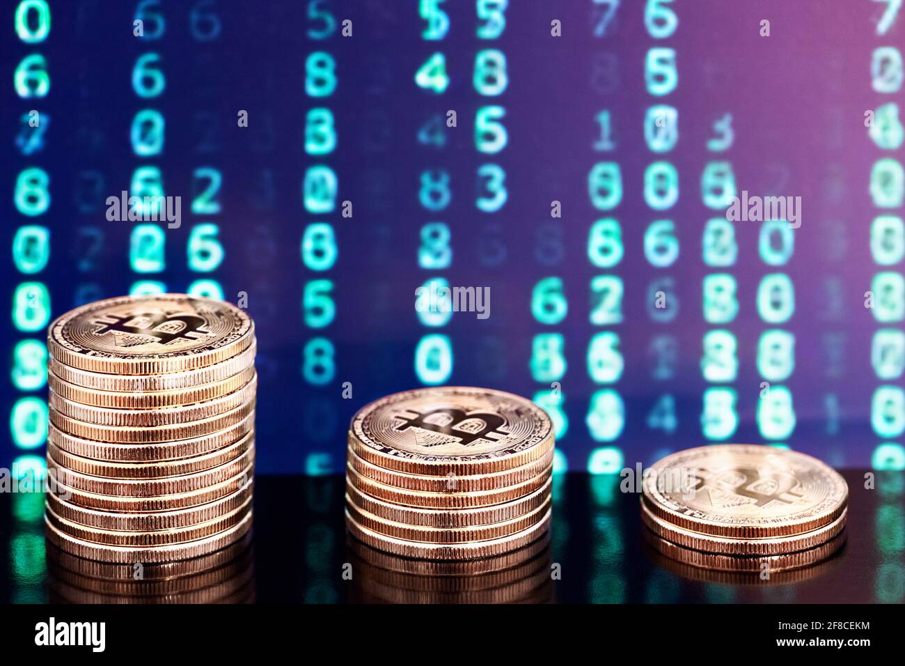tre pile di bitcoin con numeri in background Foto Stock