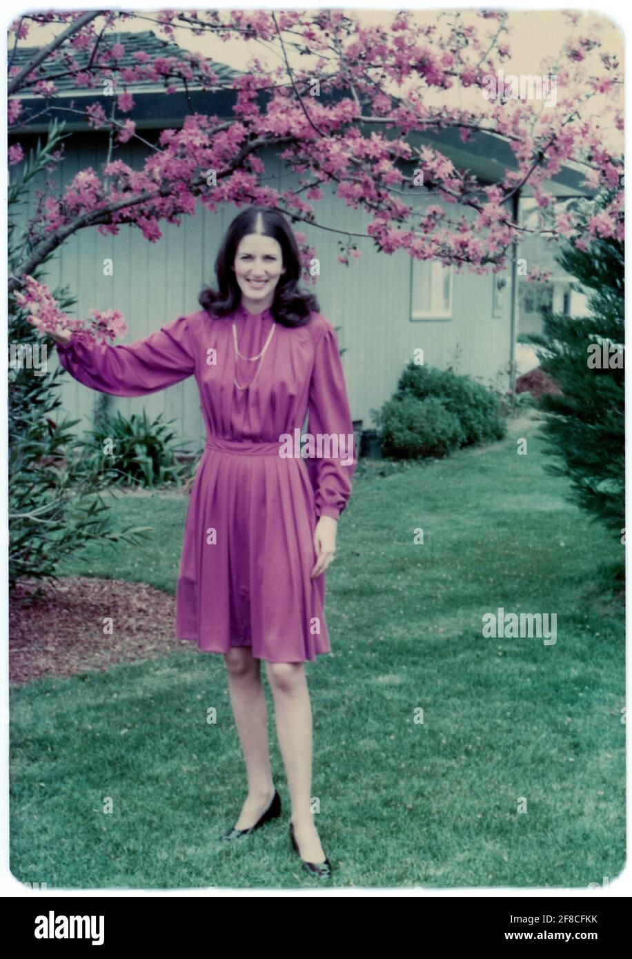 1970, Pretty Young Woman posa in un vestito scorrevole, CA, USA Foto Stock