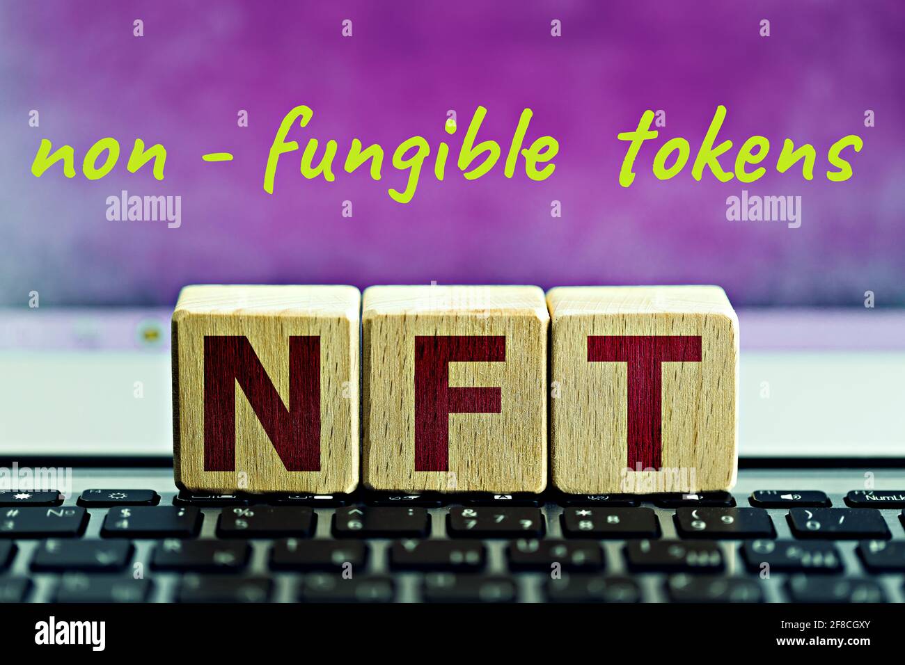 foto su tema nft (non fungibile token). cubi di legno con l'abbreviazione 'nft', e l'iscrizione 'gettoni non fungibili', su sfondo lilla Foto Stock
