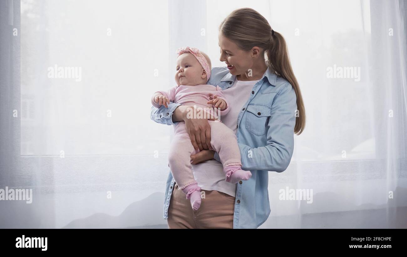 madre felice che tiene in armi figlia del bambino Foto Stock