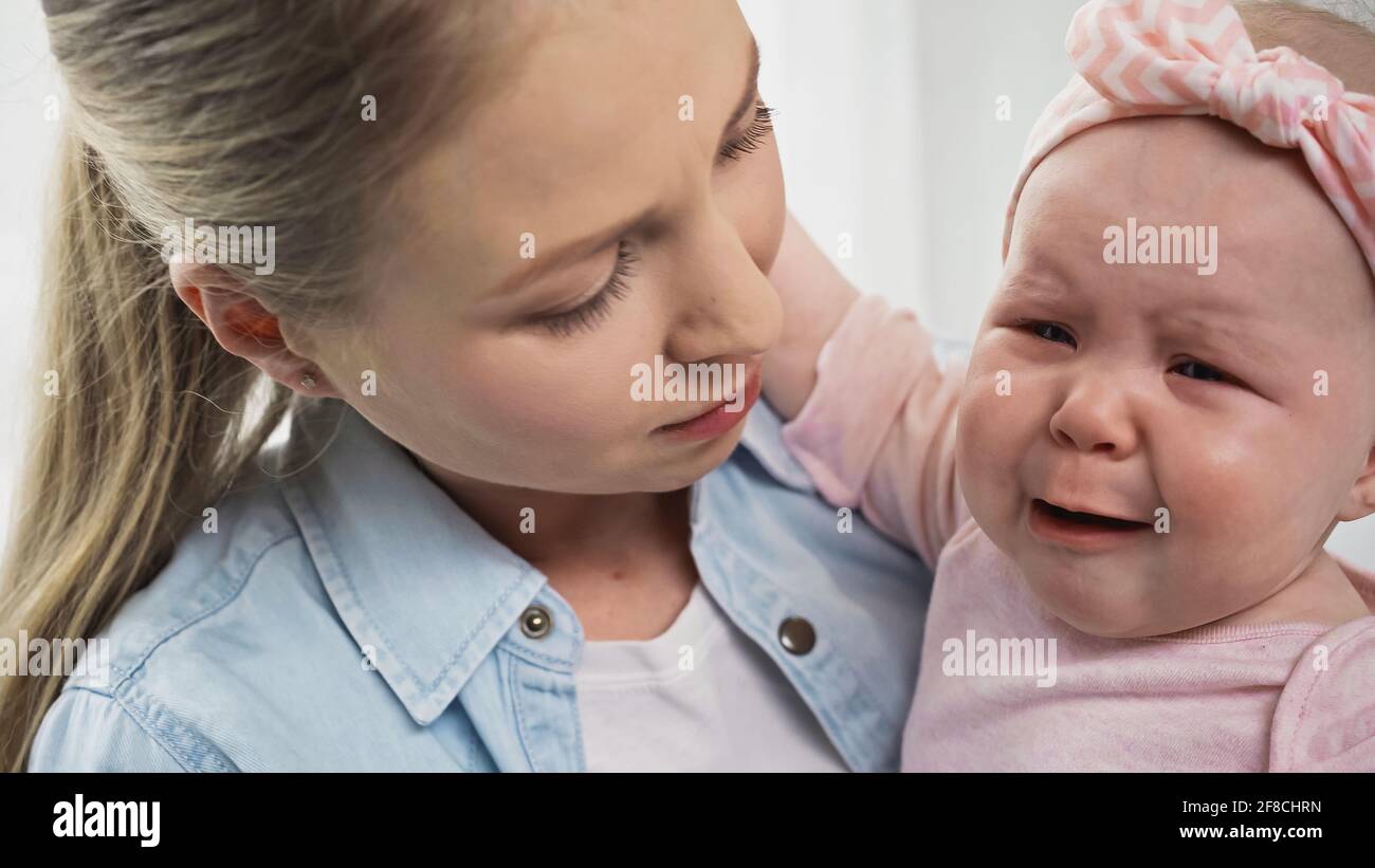 madre che tiene piangendo la bambina in armi Foto Stock