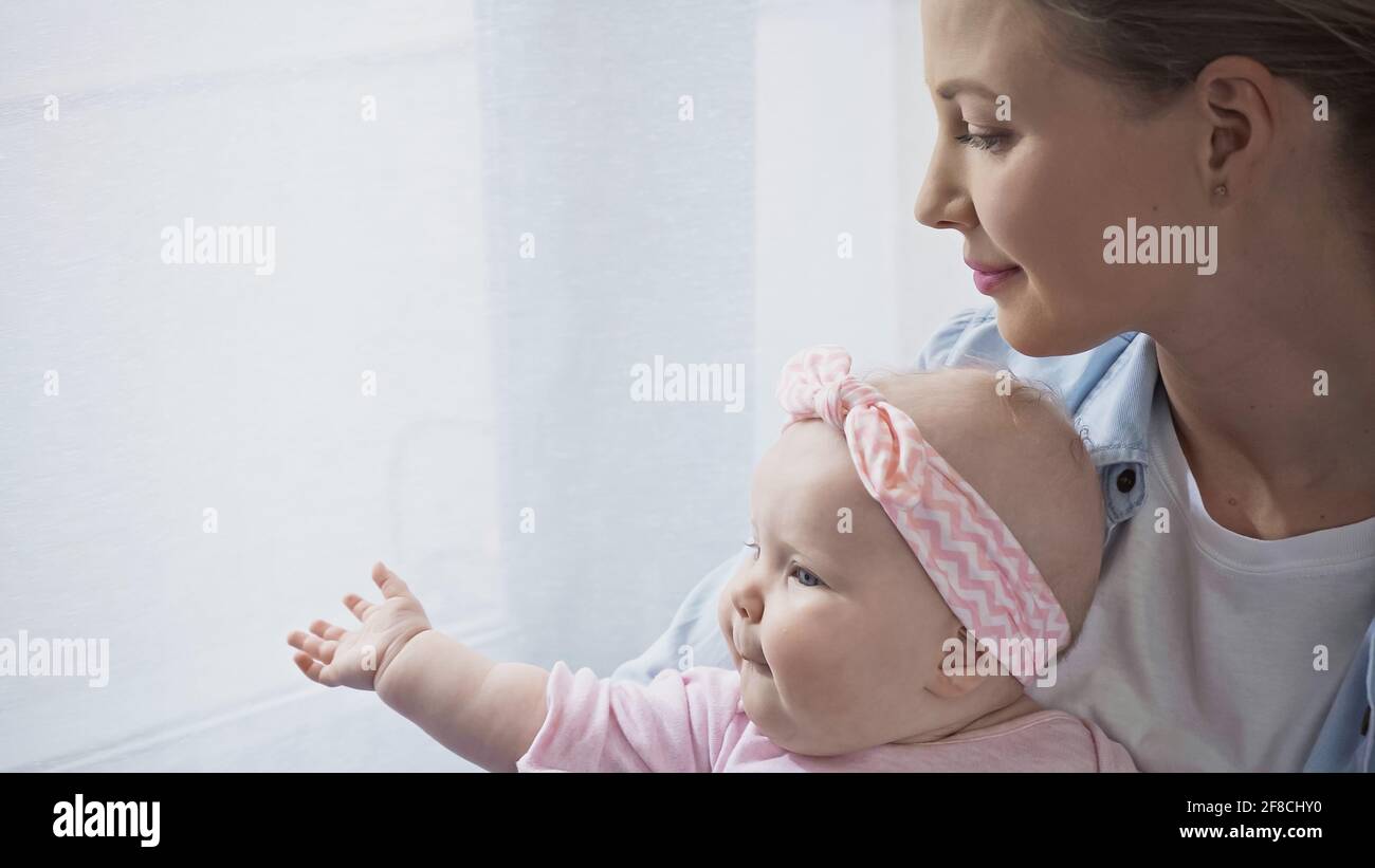 felice madre che tiene in armi bambina Foto Stock