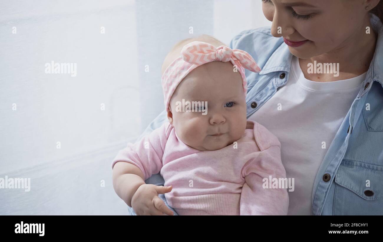 mamma allegra che tiene in braccio bambina Foto Stock