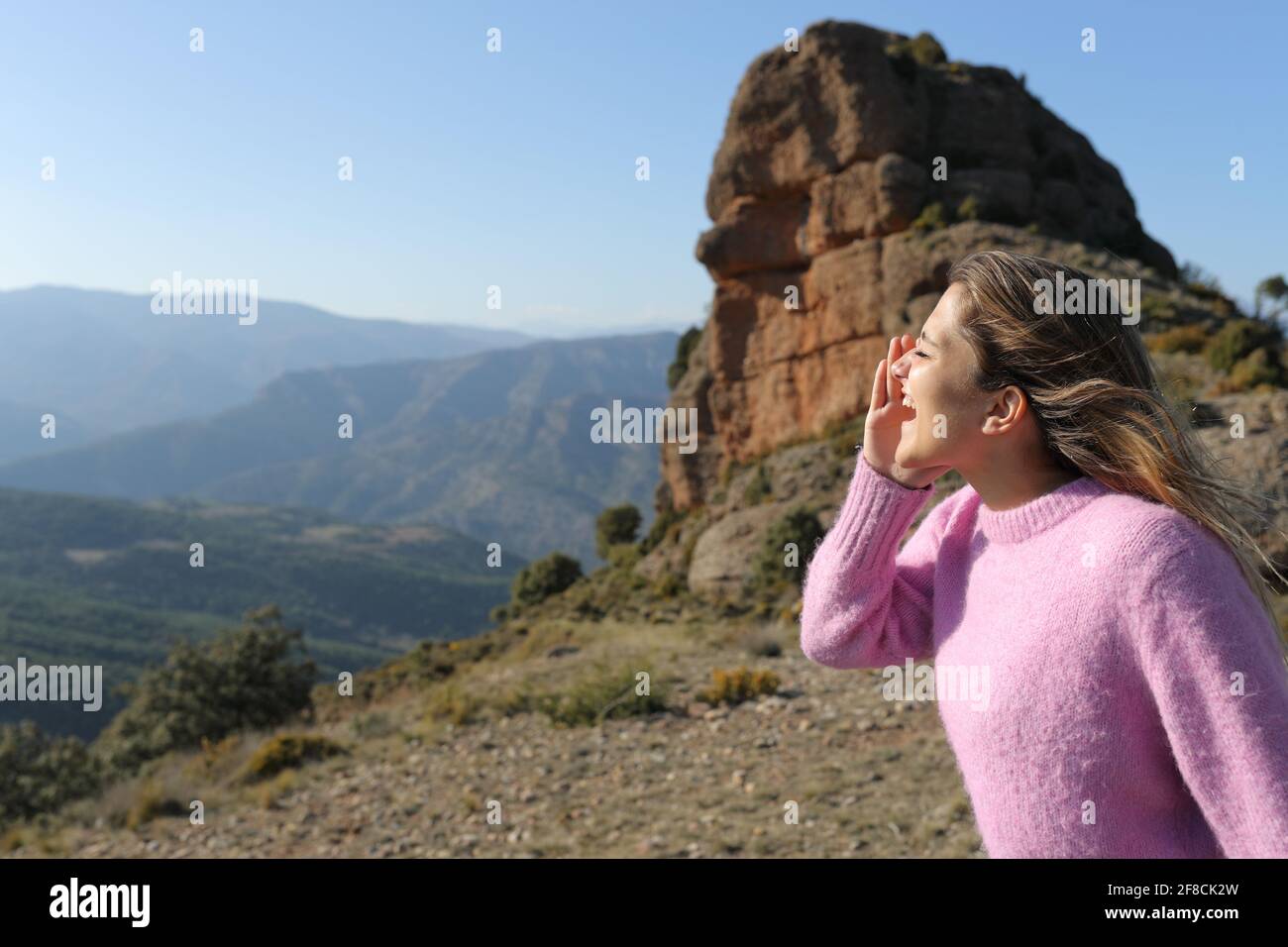 Profilo di una donna felice che grida in montagna vacanza Foto Stock