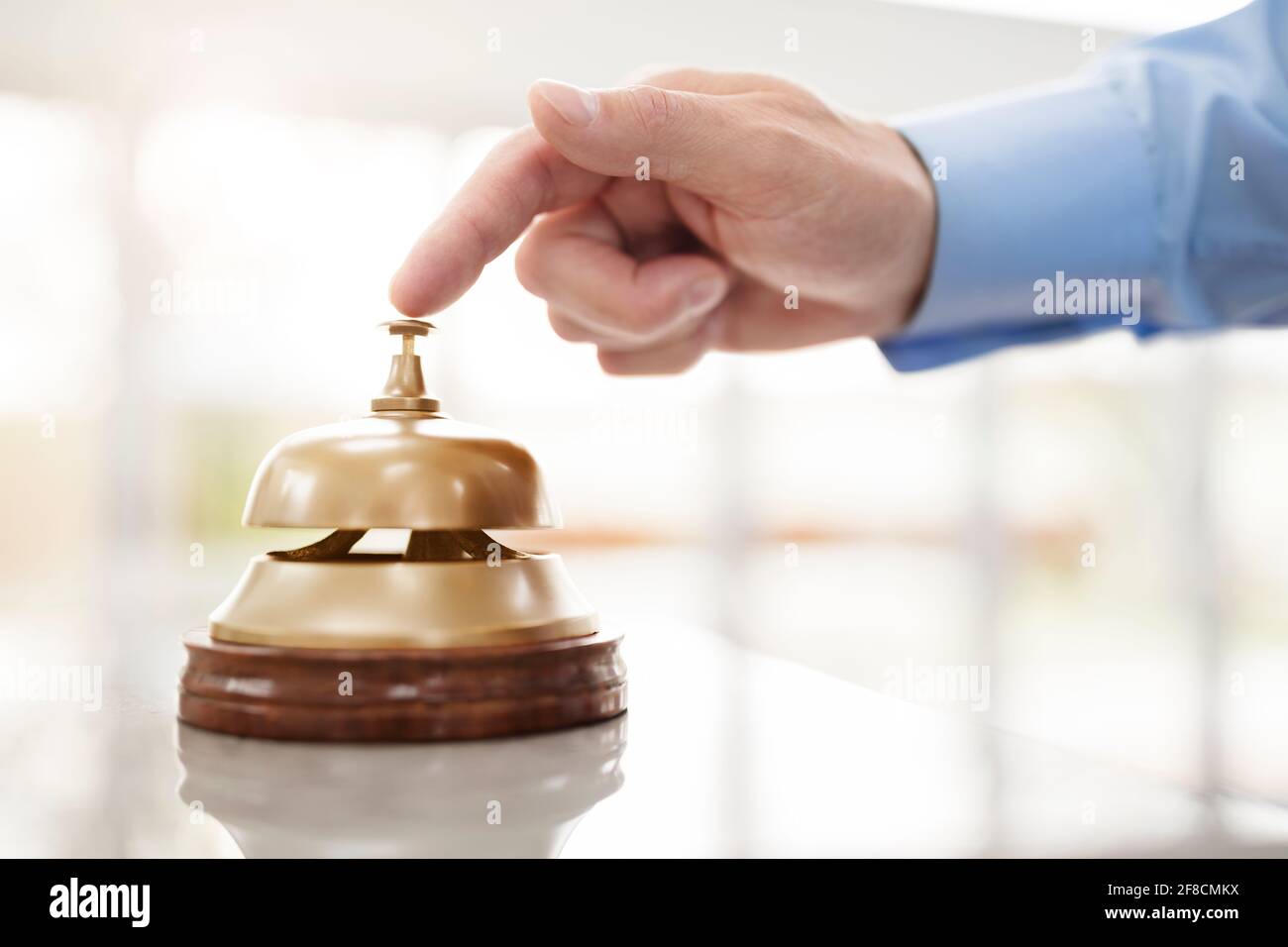 Imprenditore squilla una reception di hotel campana di servizio per attirare l attenzione Foto Stock