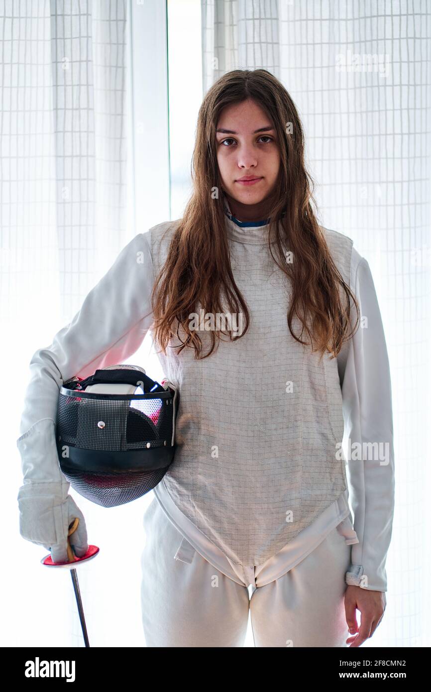 Ritratto di una giovane fencer ragazza con maschera e lamina in mano Foto Stock