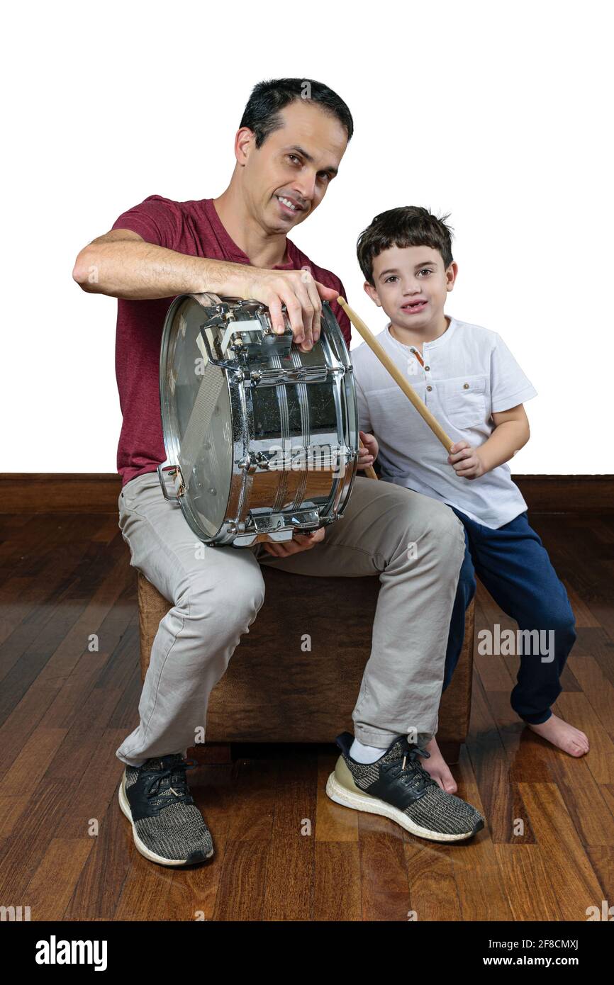Padre (44 anni) insegnando a suo figlio (7 anni) le prime lezioni di batteria, foto 1. Sfondo bianco. Foto Stock