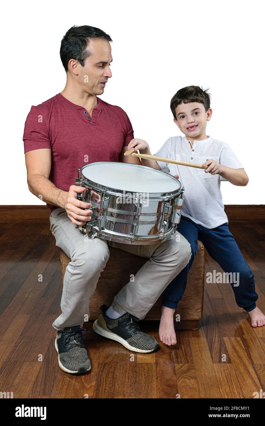 Padre (44 anni) insegnando a suo figlio (7 anni) le prime lezioni di batteria, foto 2. Sfondo bianco. Foto Stock