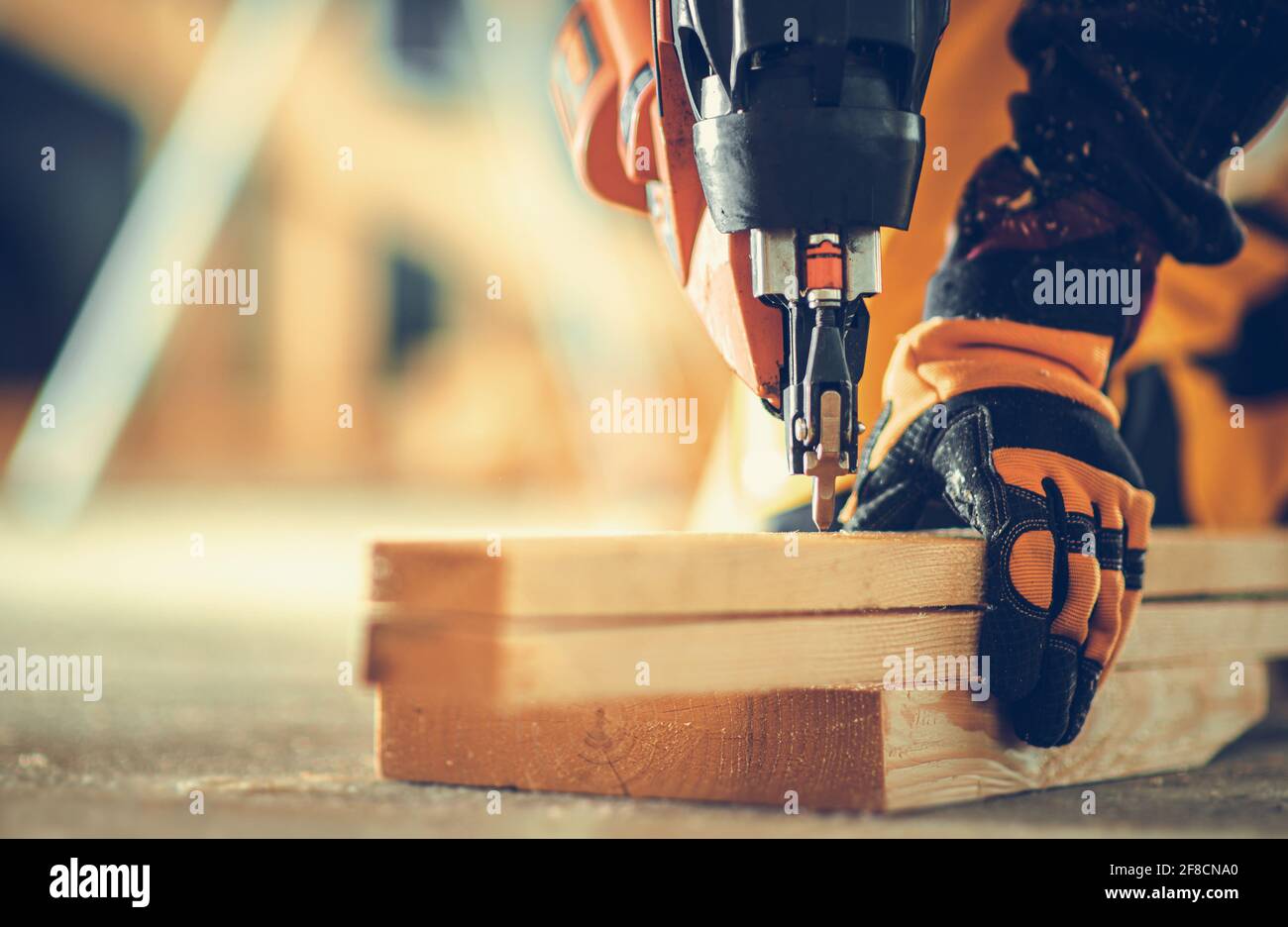 Potente pistola a chiodo costruzione lavoro primo piano. Lavoratore appaltatore con l'attrezzo di potenza nelle sue mani. Foto Stock