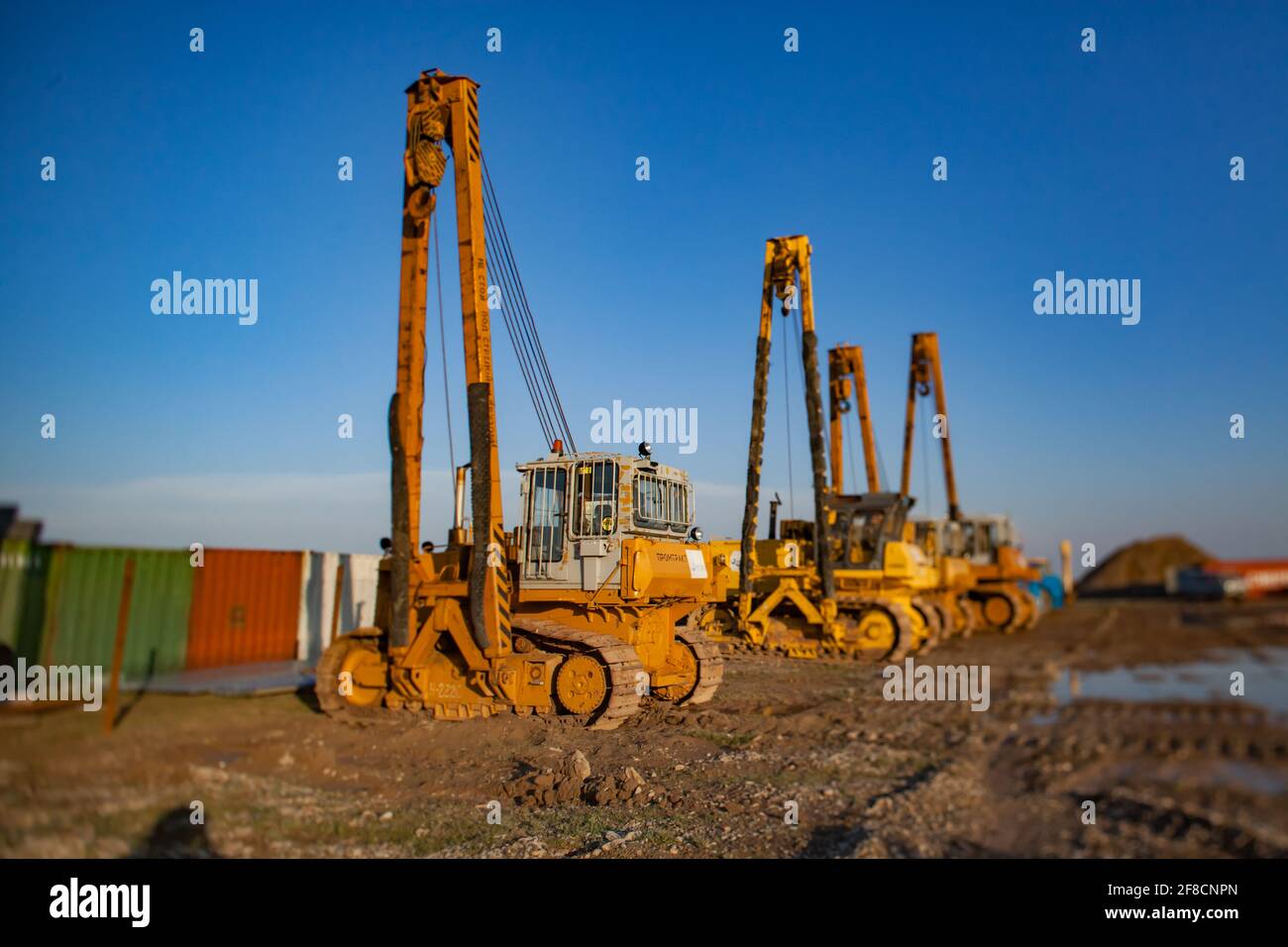 Macchine per palafitte cingolate da costruzione gialle in parcheggio. Turkestan, Kazakistan. Foto Stock