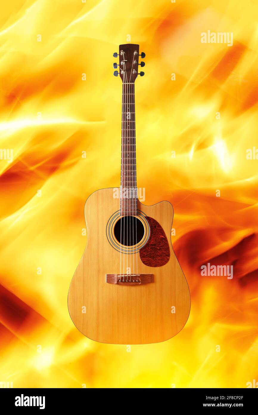 Chitarra acustica su sfondo fuoco Foto Stock