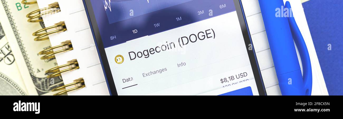 Dogecoin DOGE criptovaluta sullo schermo, banner, utilizzando smartphone per l'acquisto di crypto monete, business e finanza concept foto Foto Stock