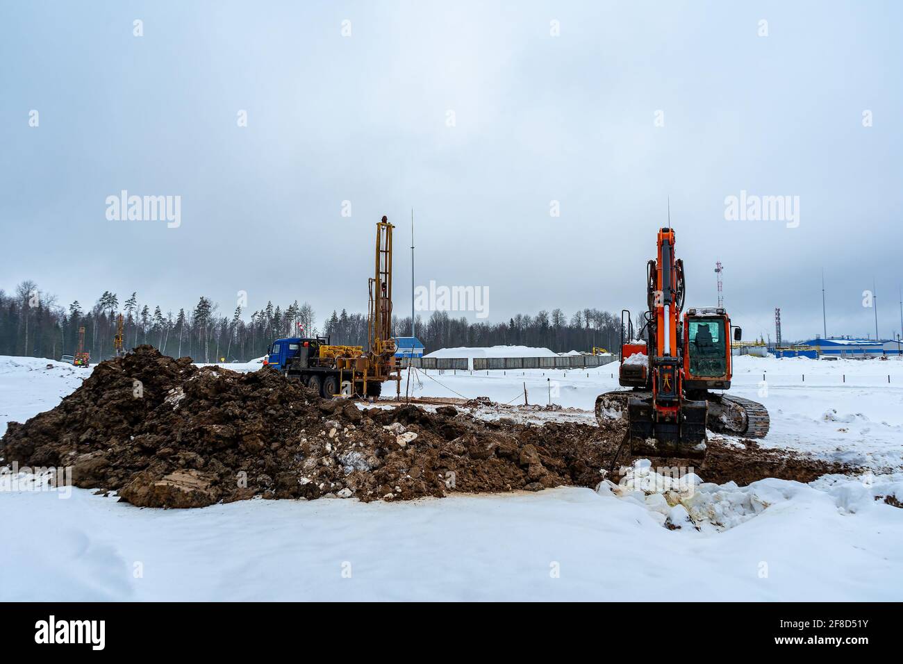 Cantiere in inverno con varie attrezzature da costruzione. Esecuzione di lavori geotecnici in un'area di costruzione Foto Stock