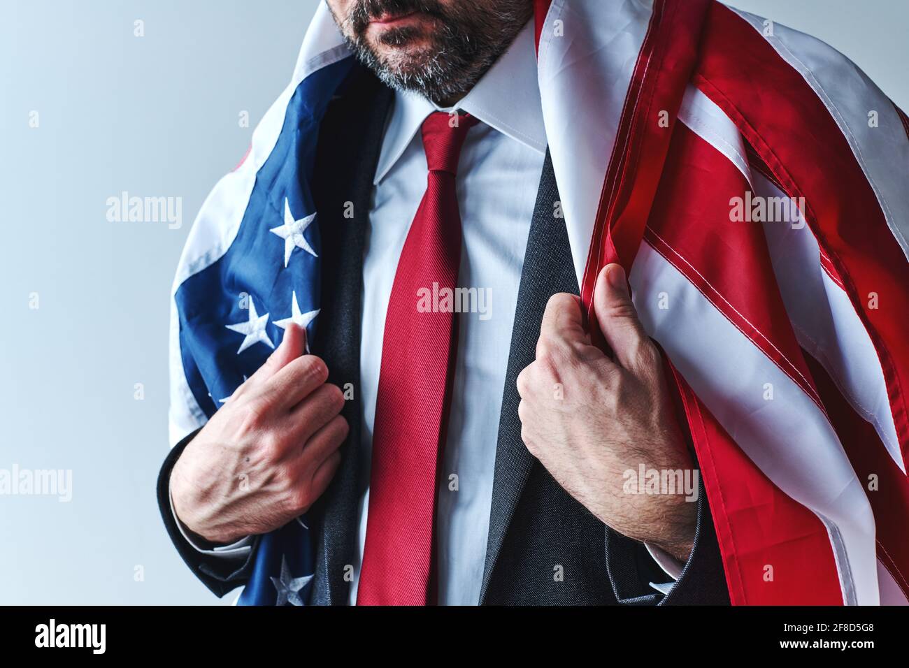 Orgoglioso uomo d'affari patriottico americano che indossa una bandiera degli Stati Uniti come un capo, fuoco selettivo Foto Stock