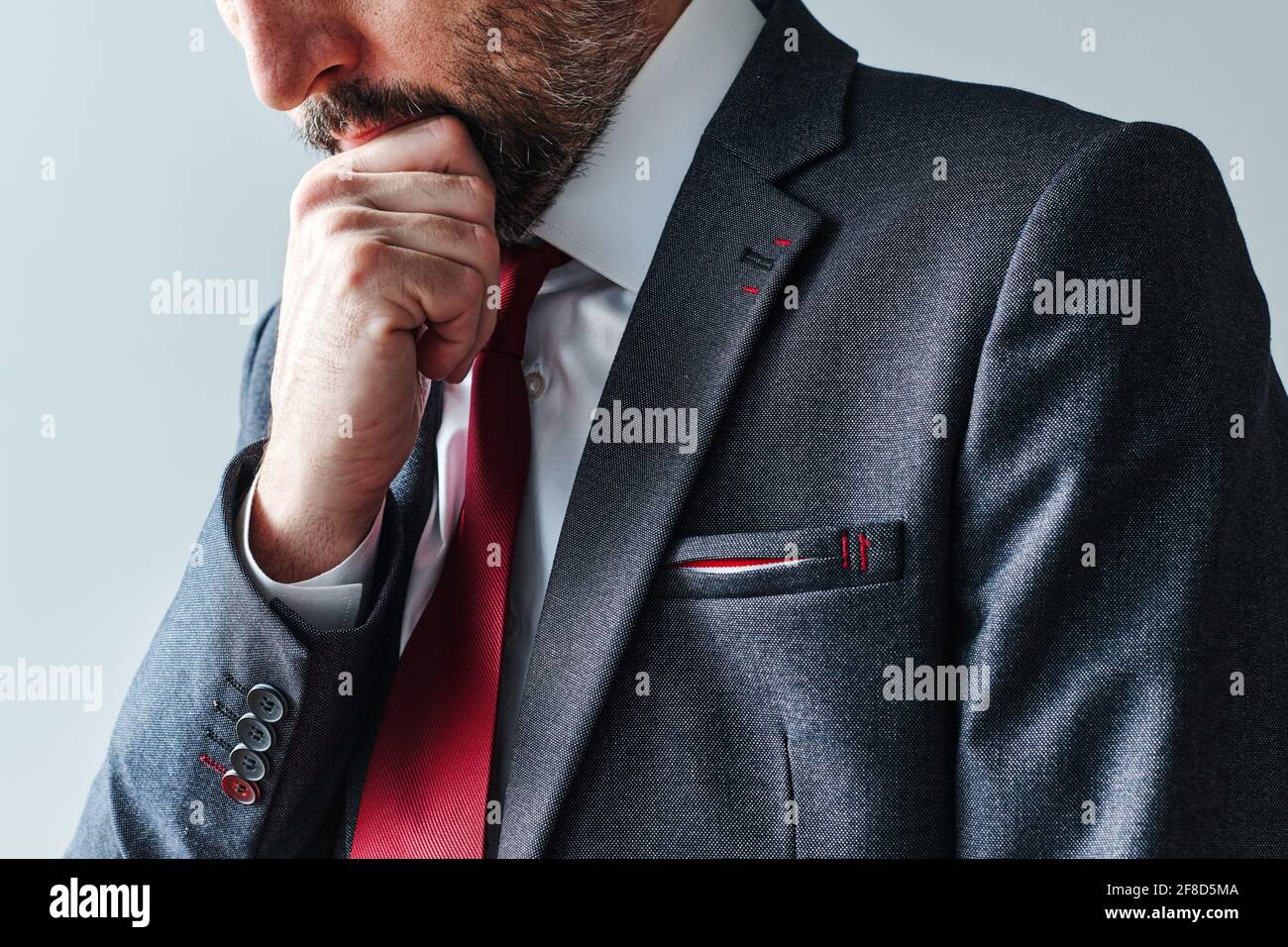 Uomo d'affari serio pensivo contemplando con la mano sul mento, ritratto selettivo del fuoco Foto Stock