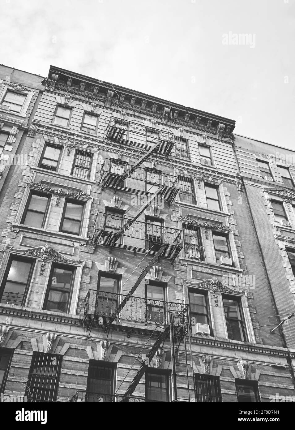 Immagine in bianco e nero di un vecchio edificio con scappamento da fuoco di ferro, New York City, USA. Foto Stock