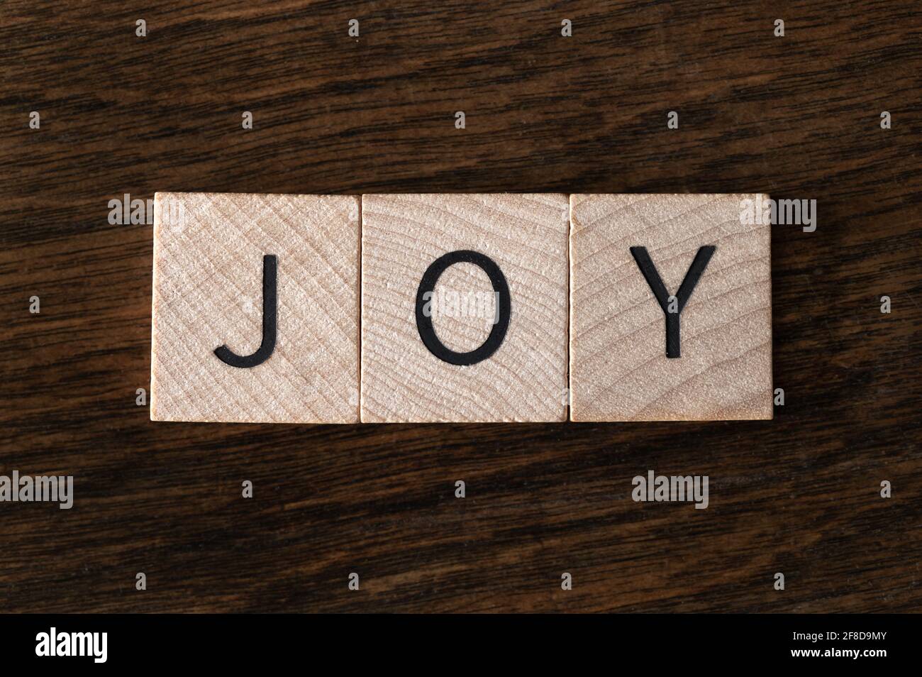 Vista dall'alto delle piastrelle di legno che Spelling out 'Joy' Foto Stock