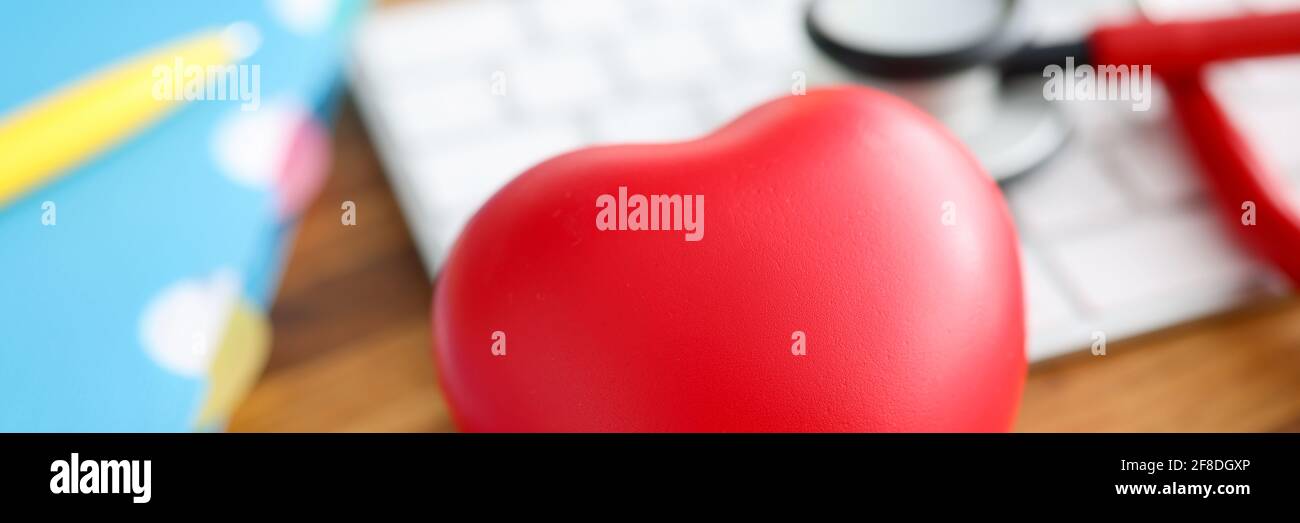 Sul tavolo si trova il cuore rosso stetoscopio e la tastiera. Foto Stock