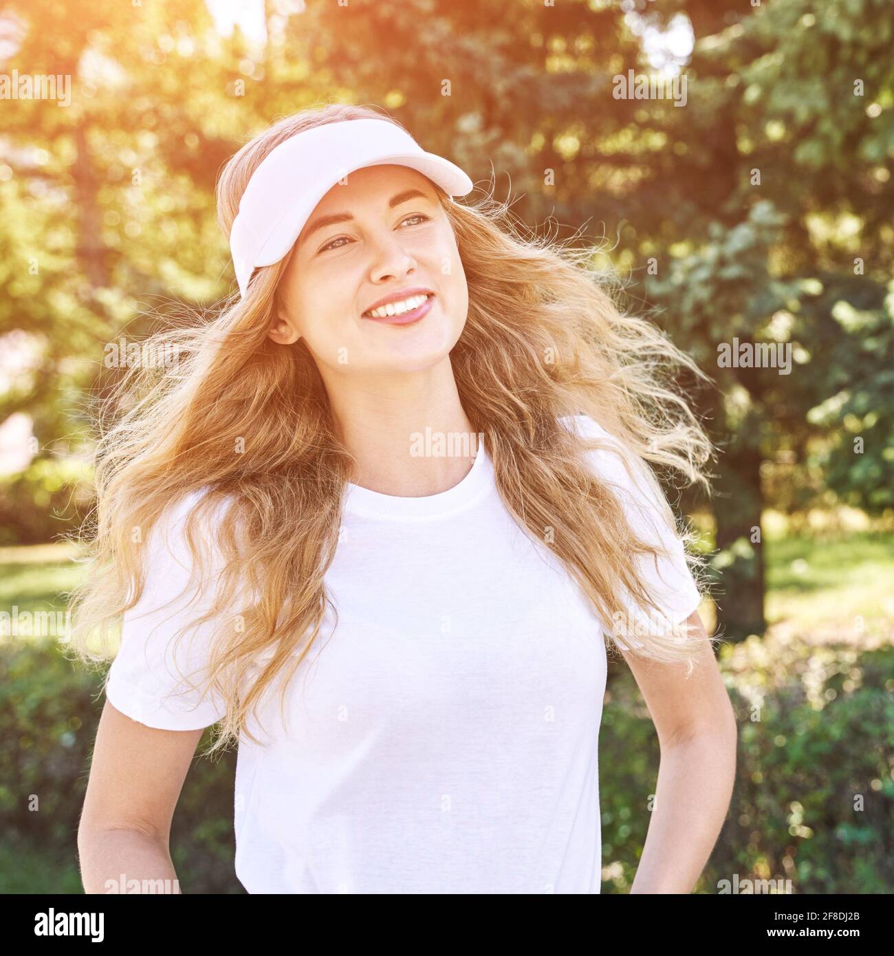 Bella giovane donna che indossa cappello da tennis. T-shirt bianca.  Giocatore sportivo femminile Foto stock - Alamy