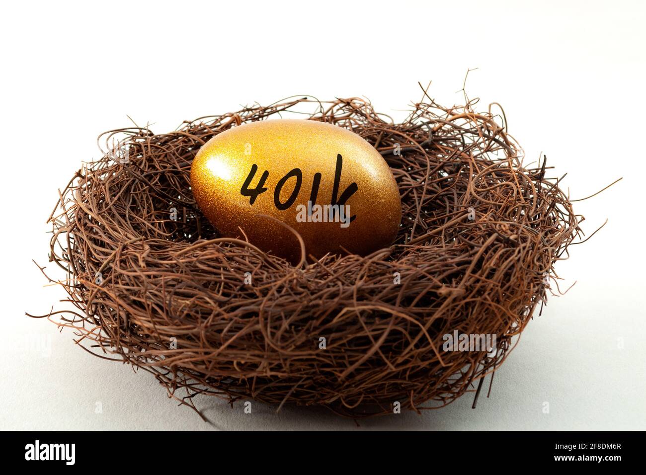 Conto pensionistico individuale, risparmio personale e concetto di fondo pensionistico con primo piano su un uovo d'oro in un nido che simboleggia la ricchezza accumulata wi Foto Stock