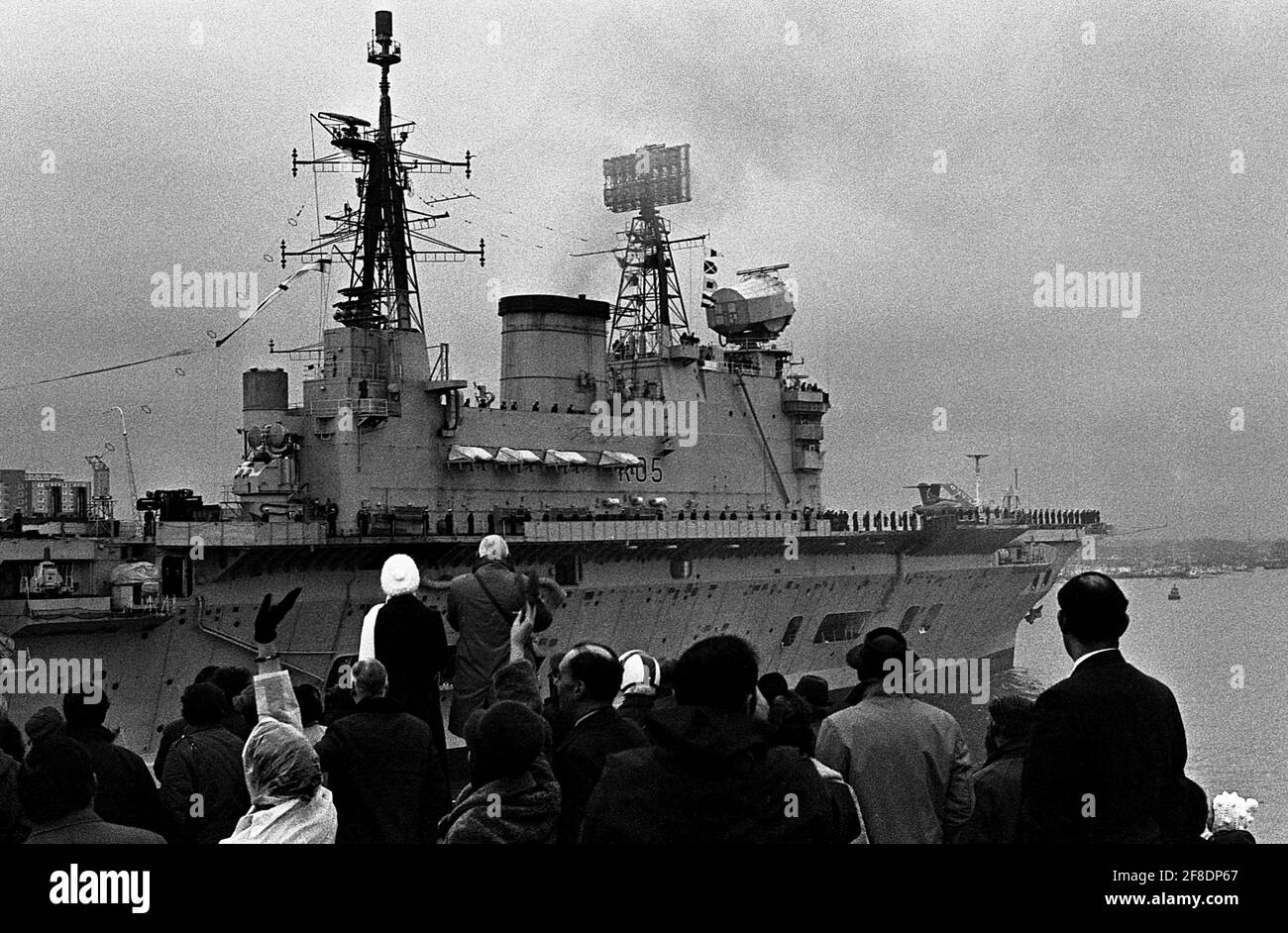 AJAXNETPHOTO. 26 GENNAIO 1972. PORTSMOUTH, INGHILTERRA. - ULTIMO INGRESSO - LA PORTAEREI HMS EAGLE ENTRA NELLA BASE NAVALE PER L'ULTIMA VOLTA PRIMA DI DECOMISIONING, ACCOLTO DA FOLLA AGITANDO SULLA VECCHIA TORRE ROTONDA DI PORTSMOUTH. EAGLE ERA UN AUDACE PORTATORE DI CLASSE. LA NAVE SORELLA ERA HMS ARK ROYAL. FOTO:JONATHAN EASTLAND/AJAX. REF:357203 14 13 Foto Stock