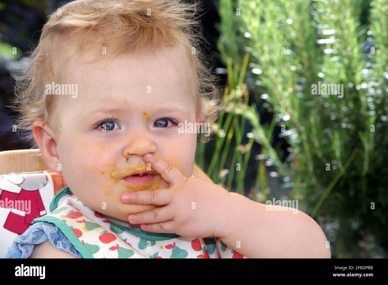 Portrait eine kleinen Mädchens mit Esensresten vom Füttern um den Mund Foto Stock