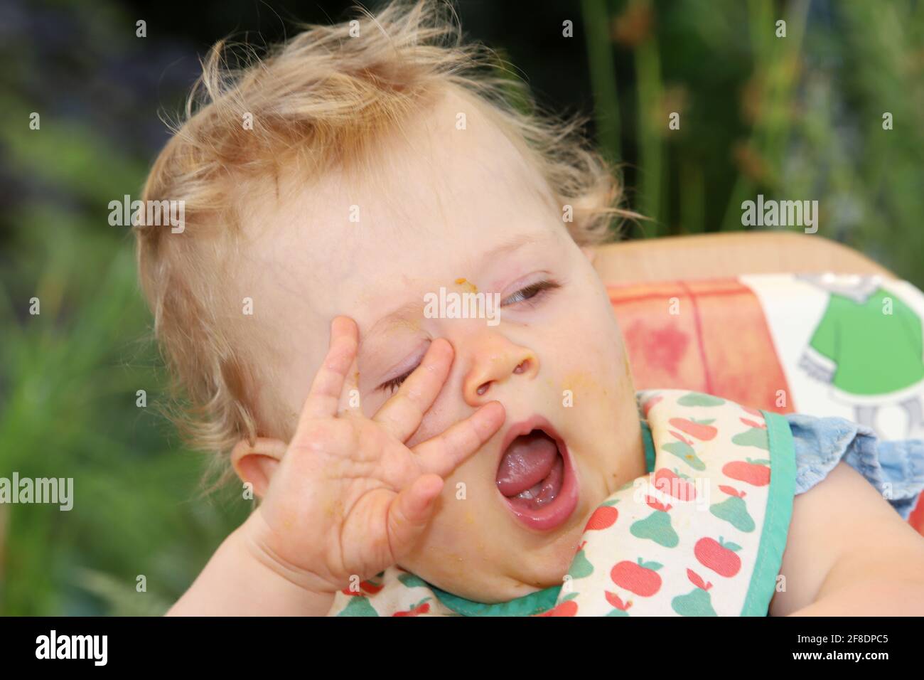 Portrait eine kleinen Mädchens mit Esensresten vom Füttern um den Mund Foto Stock