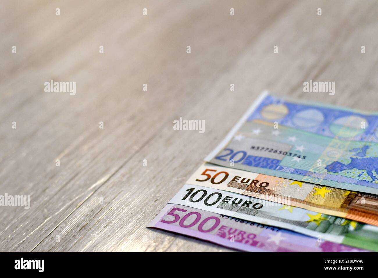 Banconote in euro di fila. Legno di fondo. Foto Stock