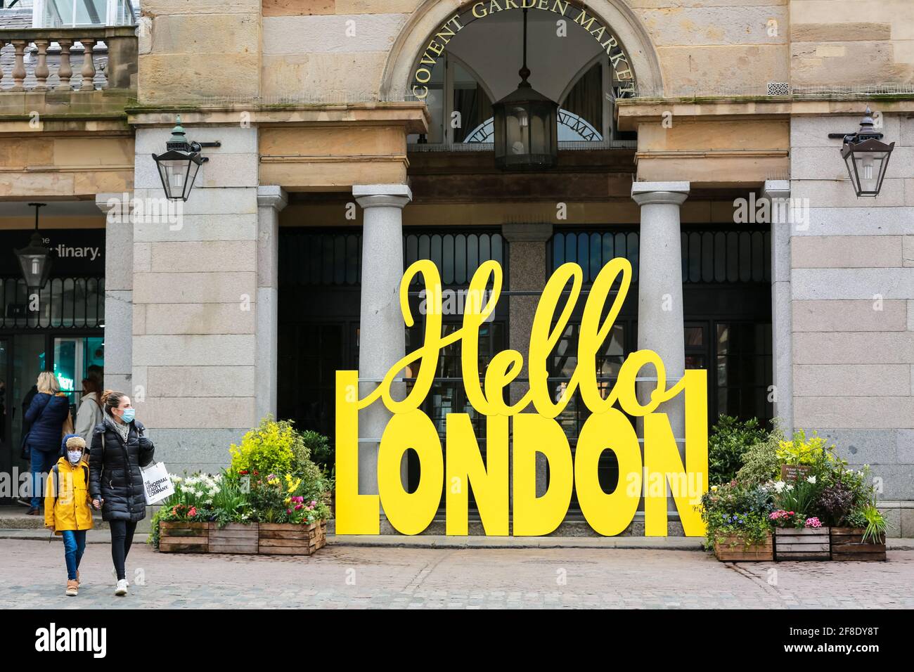 Londra, Regno Unito. 13 aprile 2021. La gente cammina oltre il cartello giallo Hello London a Covent Garden Market. Credito: Waldemar Sikora Foto Stock