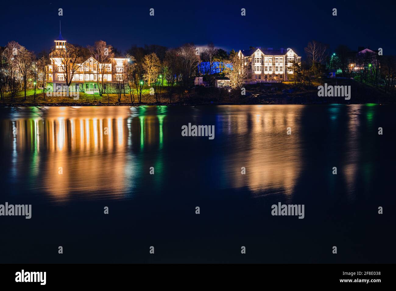 Helsinki / Finlandia - 16 APRILE 2020: Due splendidi edifici illuminati in legno che proiettano riflessi sulla tranquilla superficie del fiume. Foto Stock