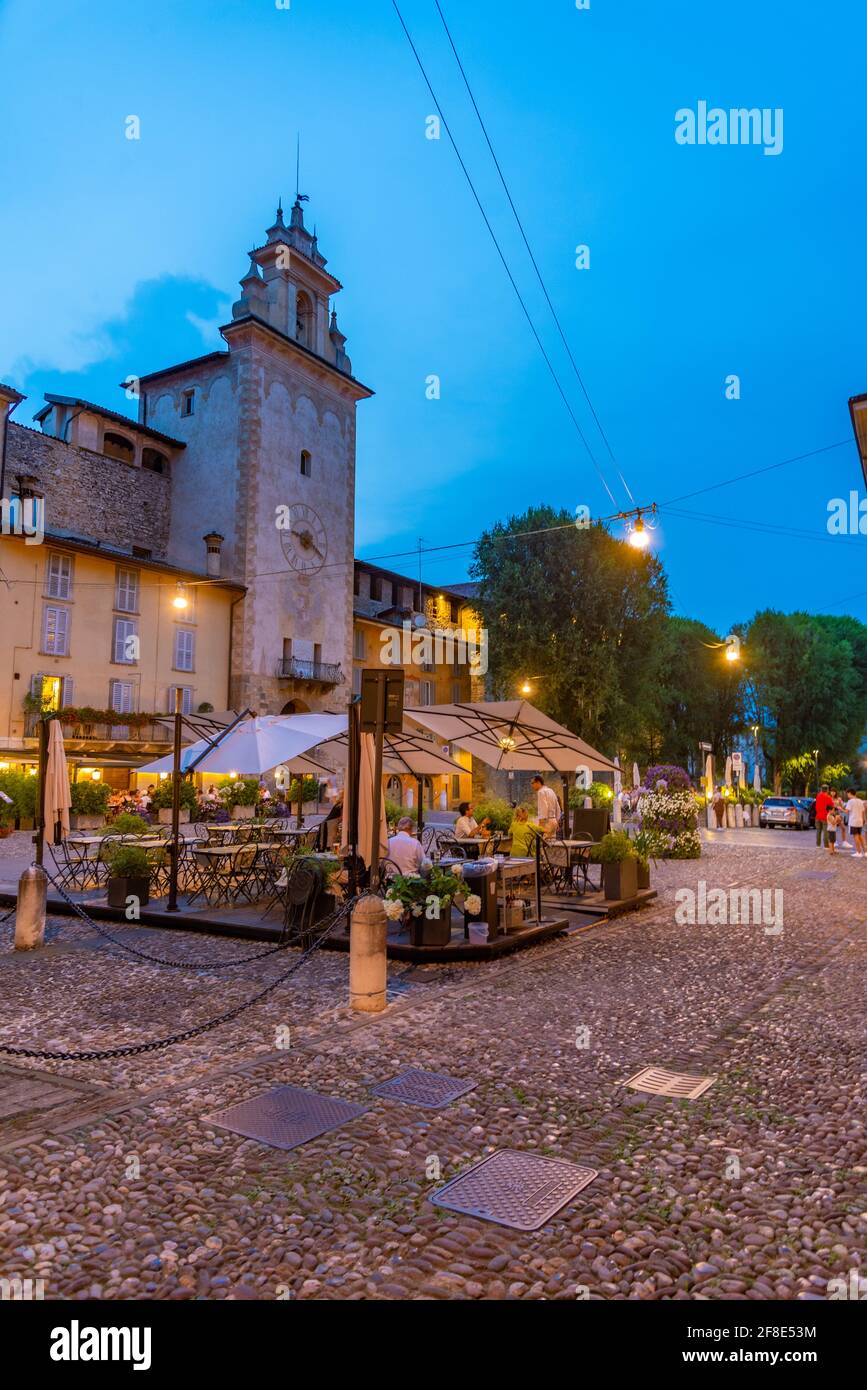 BERGAMO, ITALIA, 25 LUGLIO 2019: La gente sta cenando di fronte alla torre della campanella di Bergamo, Italia Foto Stock