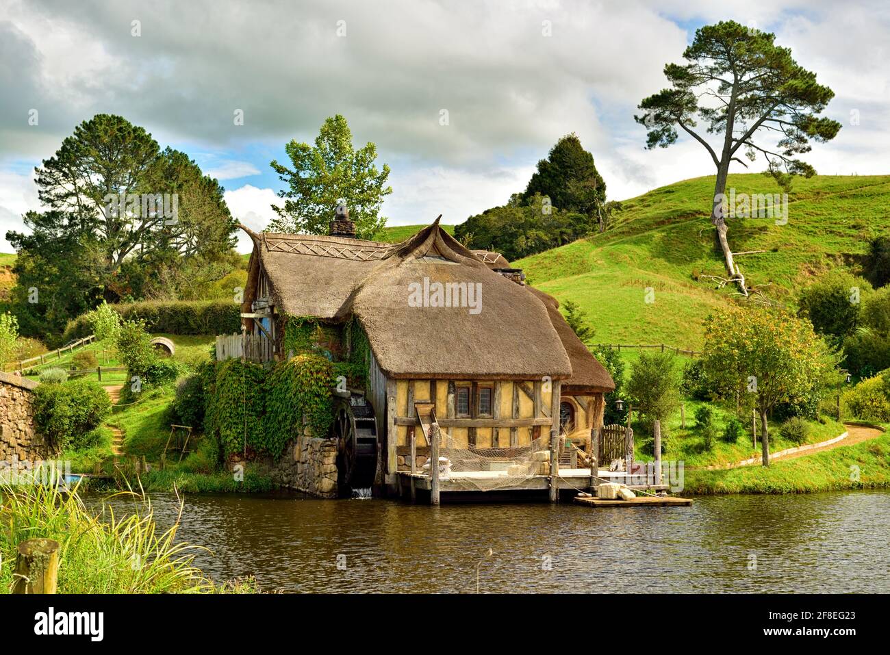 Nel cuore della campagna di Hamilton & Waikato, nascosta in modo tranquillo dietro verdi colline ondulate, è un luogo diverso da qualsiasi altro – Hobbiton Movie Set; The per Foto Stock