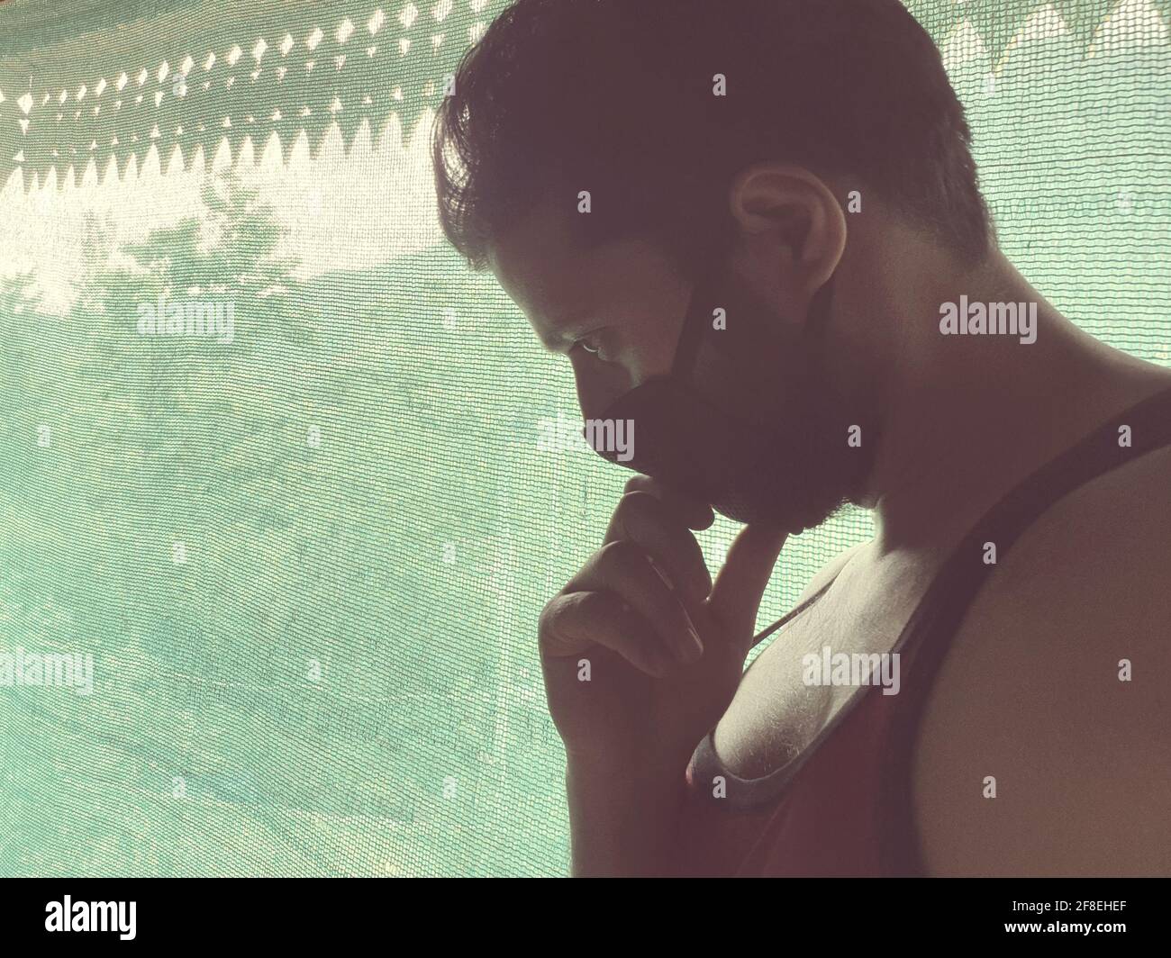 Un uomo è triste, impotente, depresso, in tensione pensa a coronavirus.Corona o cover-19 rimanere a casa sintomi pandemici virus mortale febbre tosse che copre m Foto Stock