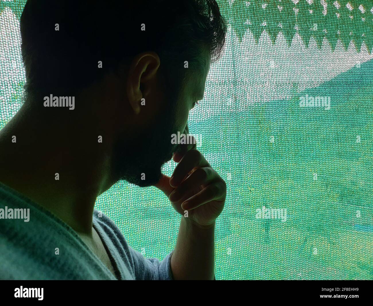 Un uomo è triste, impotente, depresso, in tensione pensa a coronavirus.Corona o cover-19 rimanere a casa sintomi pandemici virus mortale febbre tosse che copre m Foto Stock