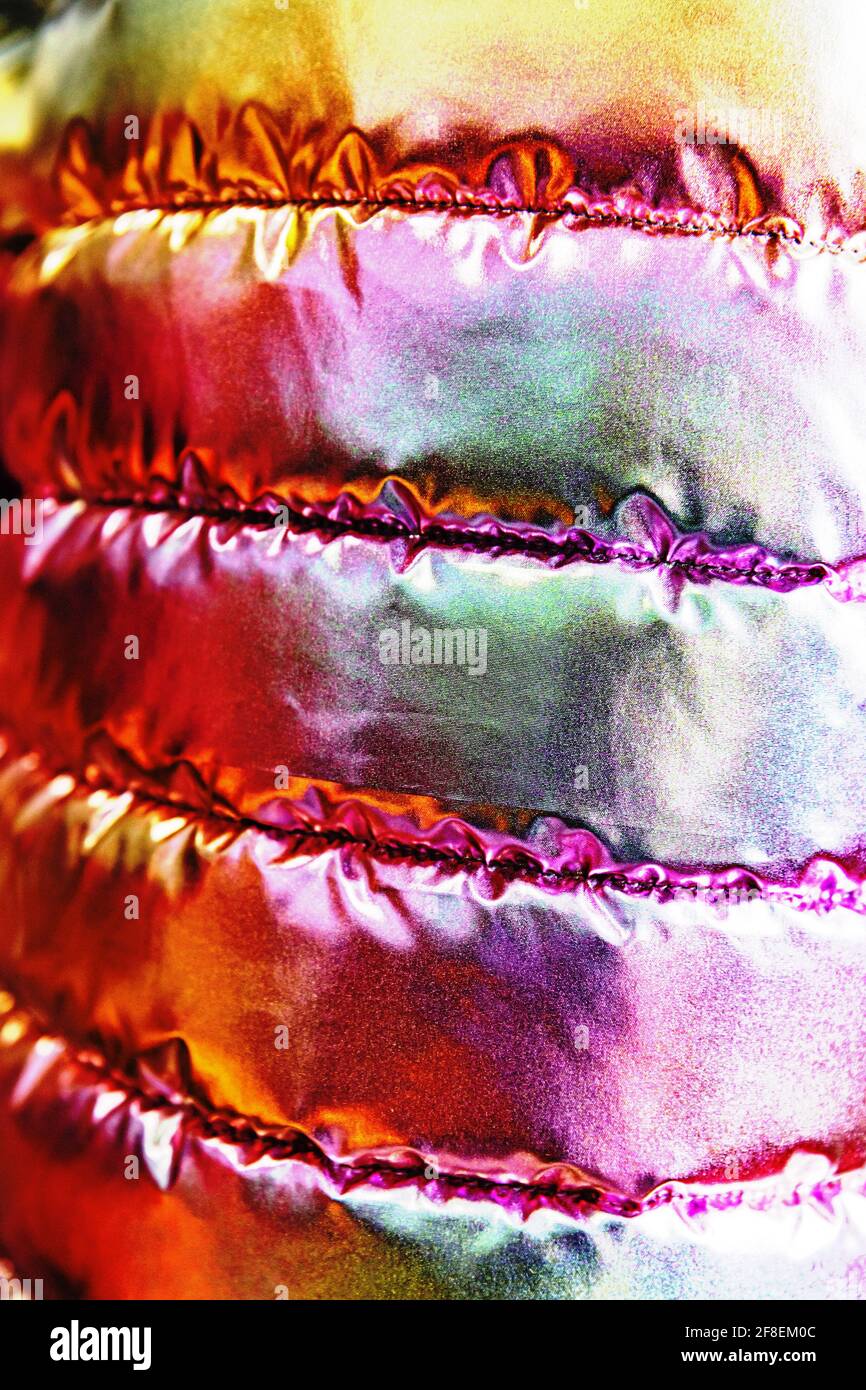 La texture iridescente del tessuto bolognese della giacca giovanile trapuntata. Arcobaleno in stile trendy sfondo. Foto Stock